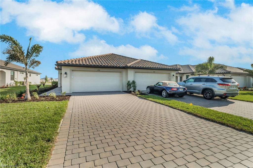 a front view of a house with a garden and parking space