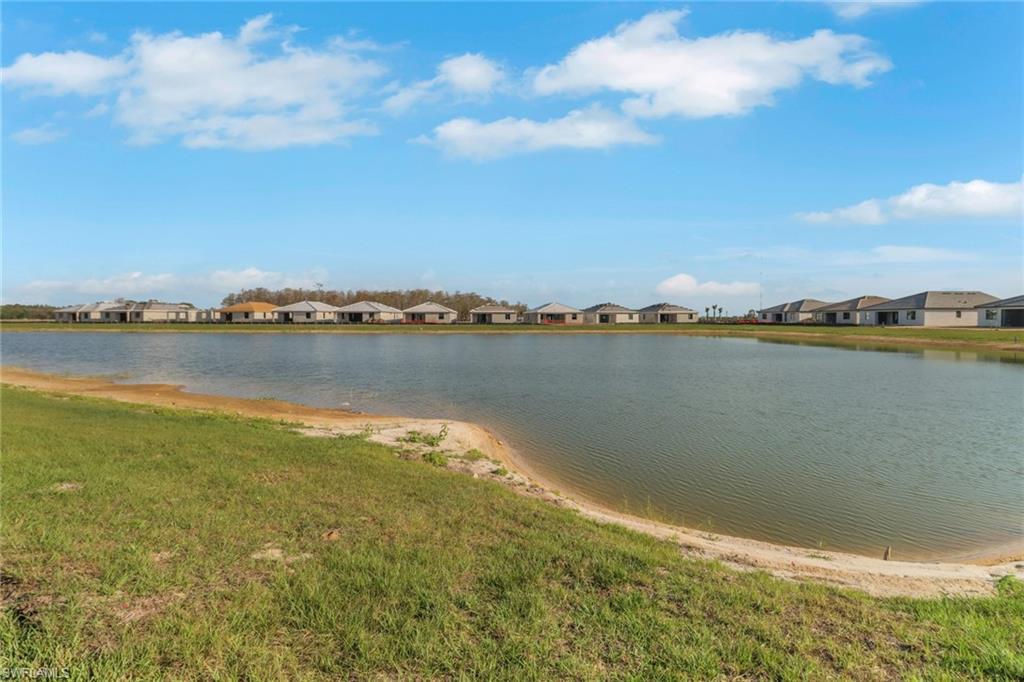19513 Hinkley Drive Estero, FL 33928 - Photo 25 of 38 a view of a lake with houses in the back