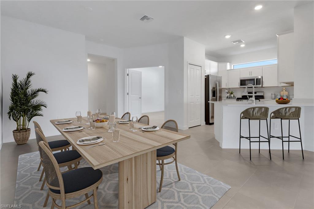 19513 Hinkley Drive Estero, FL 33928 - Photo 4 of 38 a view of a dining room with furniture and a potted plant