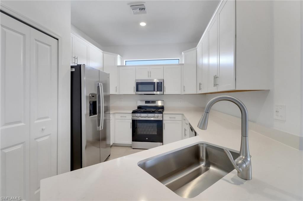 19513 Hinkley Drive Estero, FL 33928 - Photo 5 of 38 a kitchen with a refrigerator and a sink