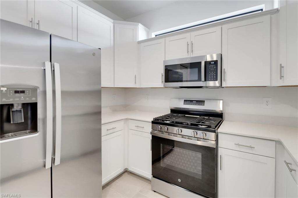 19513 Hinkley Drive Estero, FL 33928 - Photo 6 of 38 a kitchen with cabinets stainless steel appliances and a counter space
