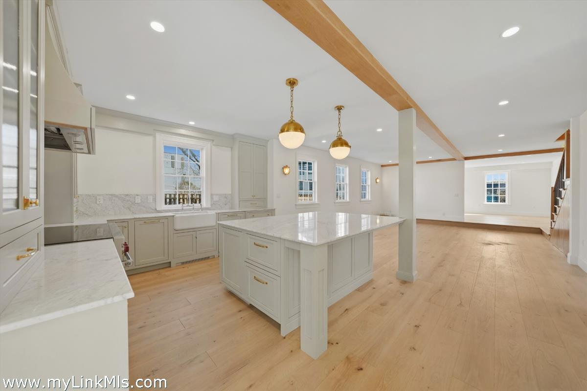 85 Orange Street Nantucket, MA 02554 - Photo 12 of 89 a large white kitchen with a large window a sink and stainless steel appliances