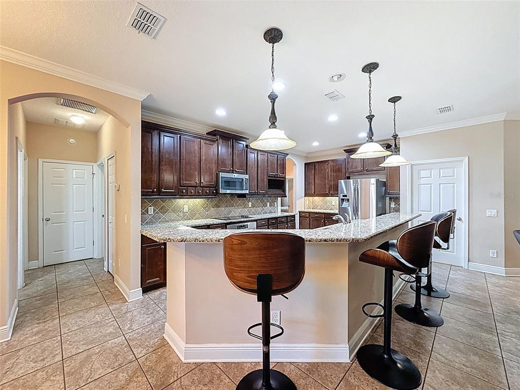 335 Cockle Shell Loop Apollo Beach, FL 33572 - Photo 17 of 90 a kitchen with stainless steel appliances granite countertop a stove a sink and a refrigerator