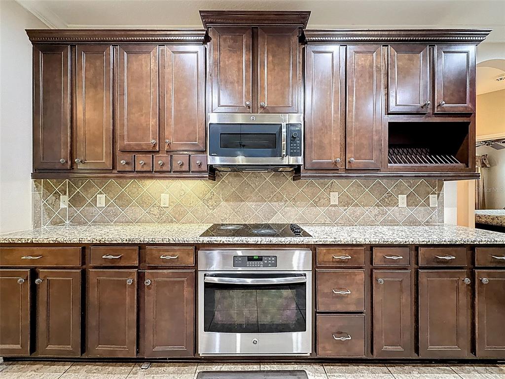 335 Cockle Shell Loop Apollo Beach, FL 33572 - Photo 19 of 90 a kitchen with granite countertop a stove a sink and a microwave