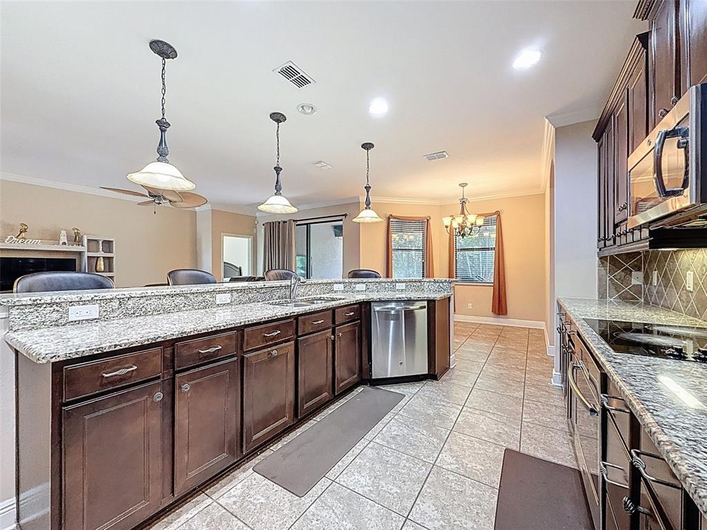 335 Cockle Shell Loop Apollo Beach, FL 33572 - Photo 22 of 90 a large kitchen with granite countertop a stove and a sink