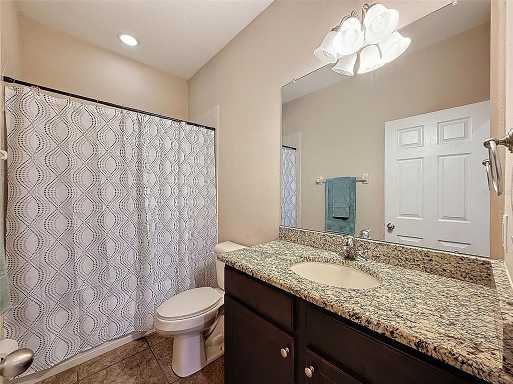 335 Cockle Shell Loop Apollo Beach, FL 33572 - Photo 34 of 90 a bathroom with a granite countertop bathtub sink vanity mirror and toilet