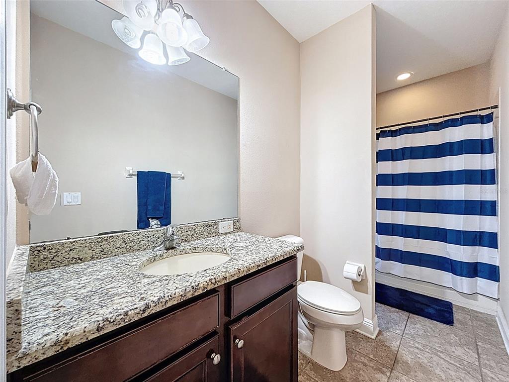 335 Cockle Shell Loop Apollo Beach, FL 33572 - Photo 38 of 90 a bathroom with a granite countertop sink toilet and mirror