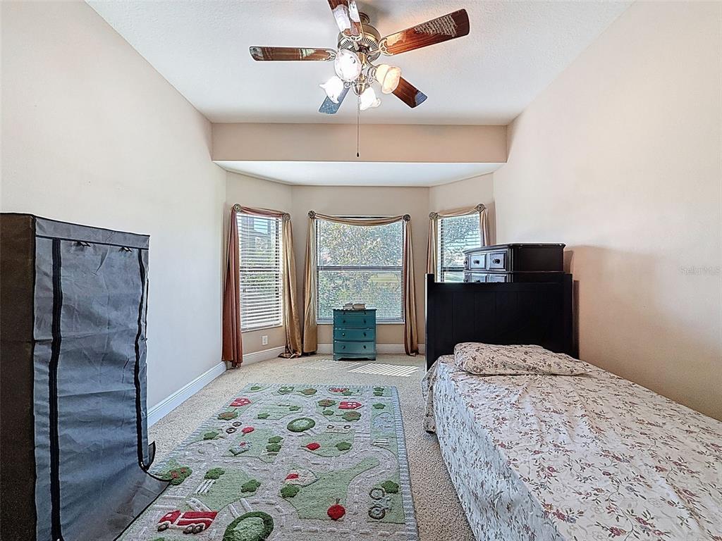 335 Cockle Shell Loop Apollo Beach, FL 33572 - Photo 41 of 90 a bedroom with a bed and a chandelier