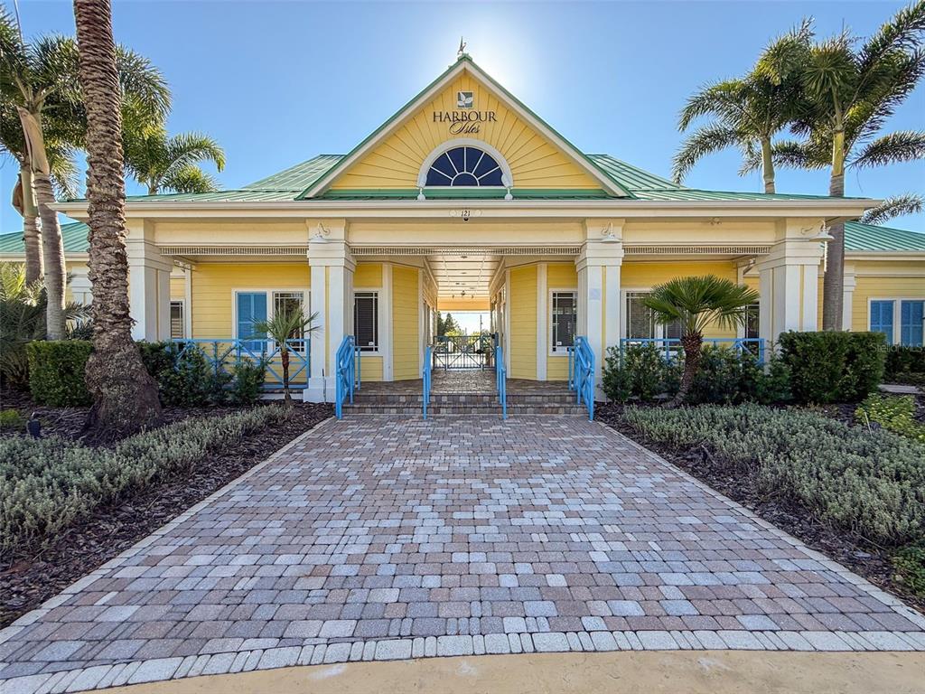 335 Cockle Shell Loop Apollo Beach, FL 33572 - Photo 80 of 90 a view of a brick house with large windows and a yard with plants