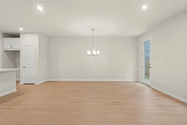 a view of an empty room with window and wooden floor