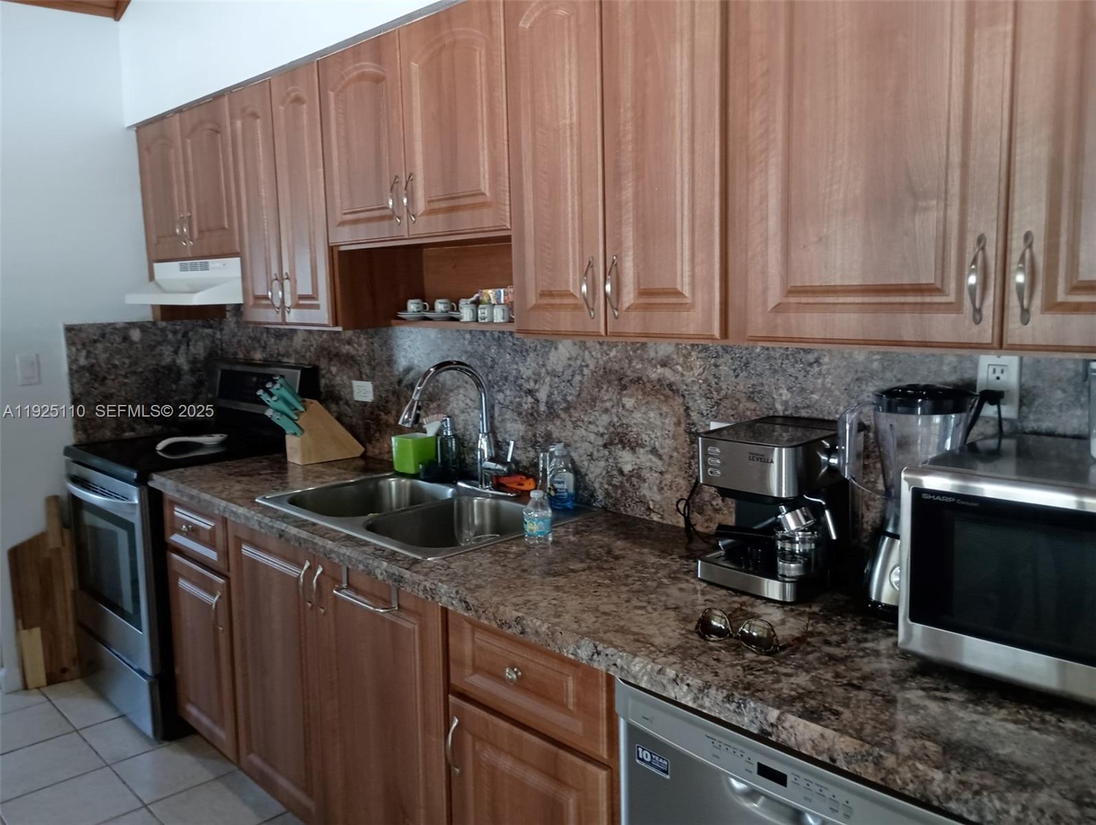 29 Bonefish Avenue Key Largo, FL 33037 - Photo 19 of 31 a kitchen with stainless steel appliances granite countertop a sink a stove and a microwave