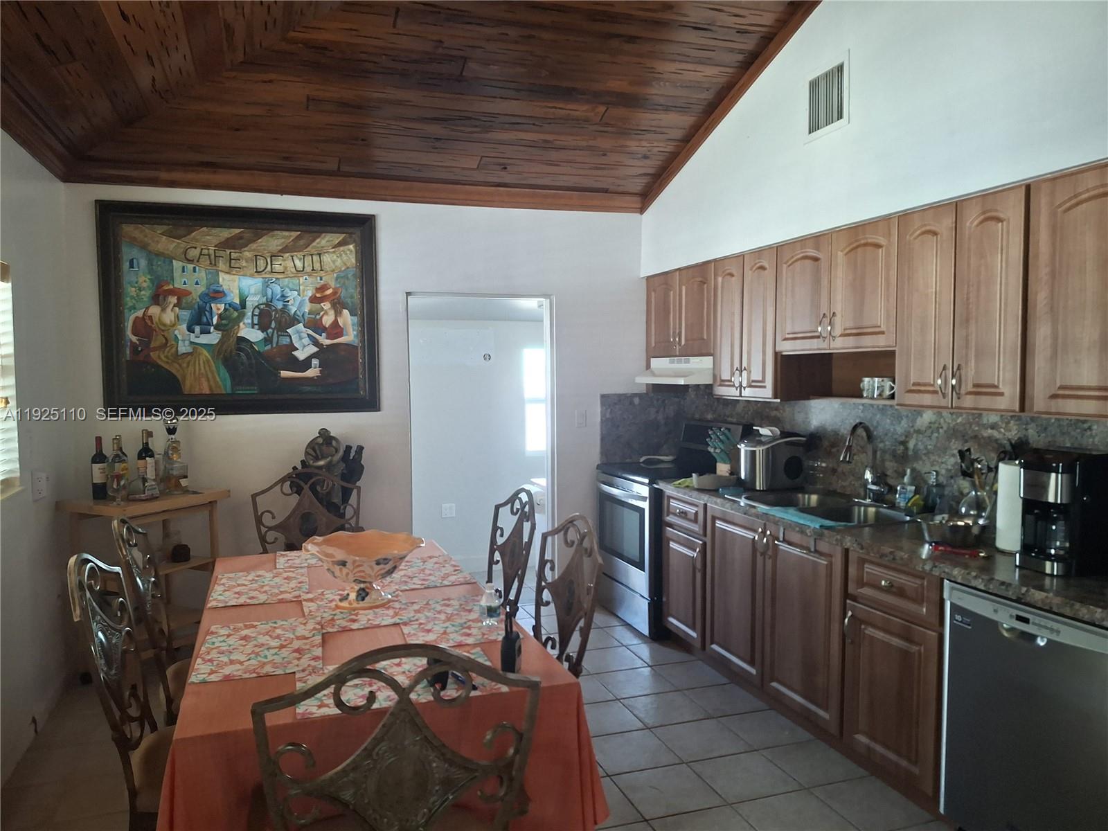 29 Bonefish Avenue Key Largo, FL 33037 - Photo 30 of 31 a kitchen with stainless steel appliances kitchen island granite countertop a table chairs in it and a window