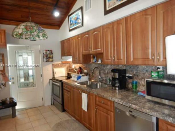 29 Bonefish Avenue Key Largo, FL 33037 - Photo 9 of 31 a kitchen with stainless steel appliances granite countertop a sink a stove and a wooden cabinets
