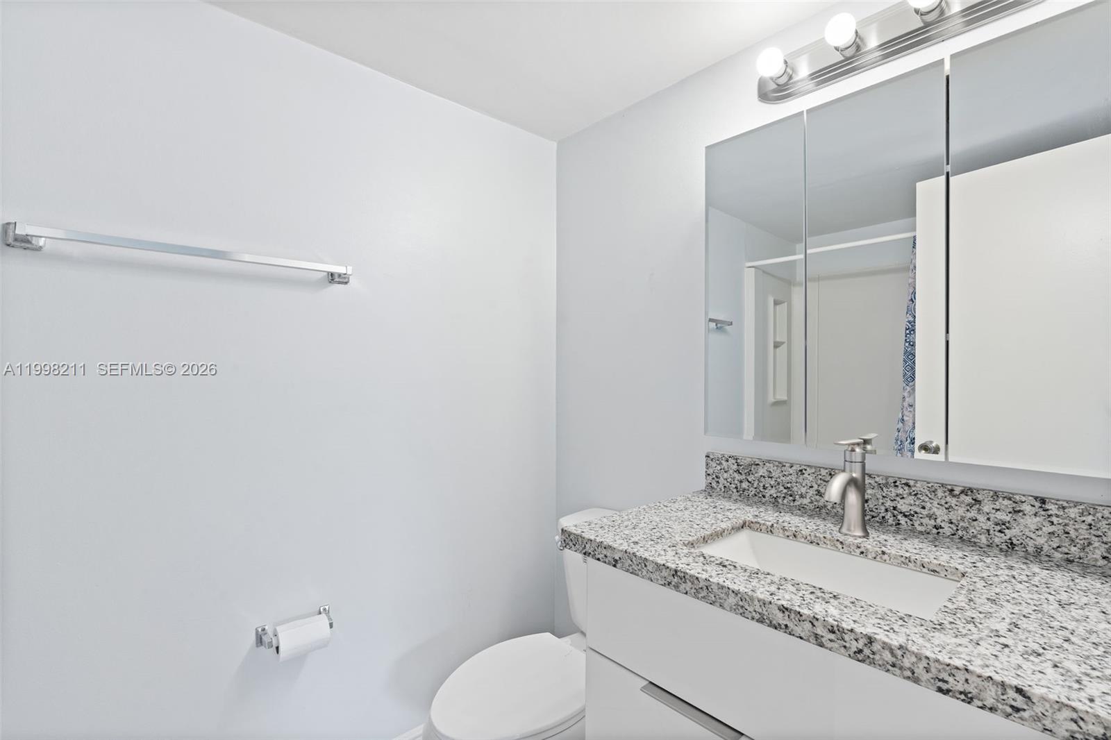 2771 Riverside Drive, Unit 316A Coral Springs, FL 33065 - Photo 16 of 20 a bathroom with a granite countertop sink toilet and shower
