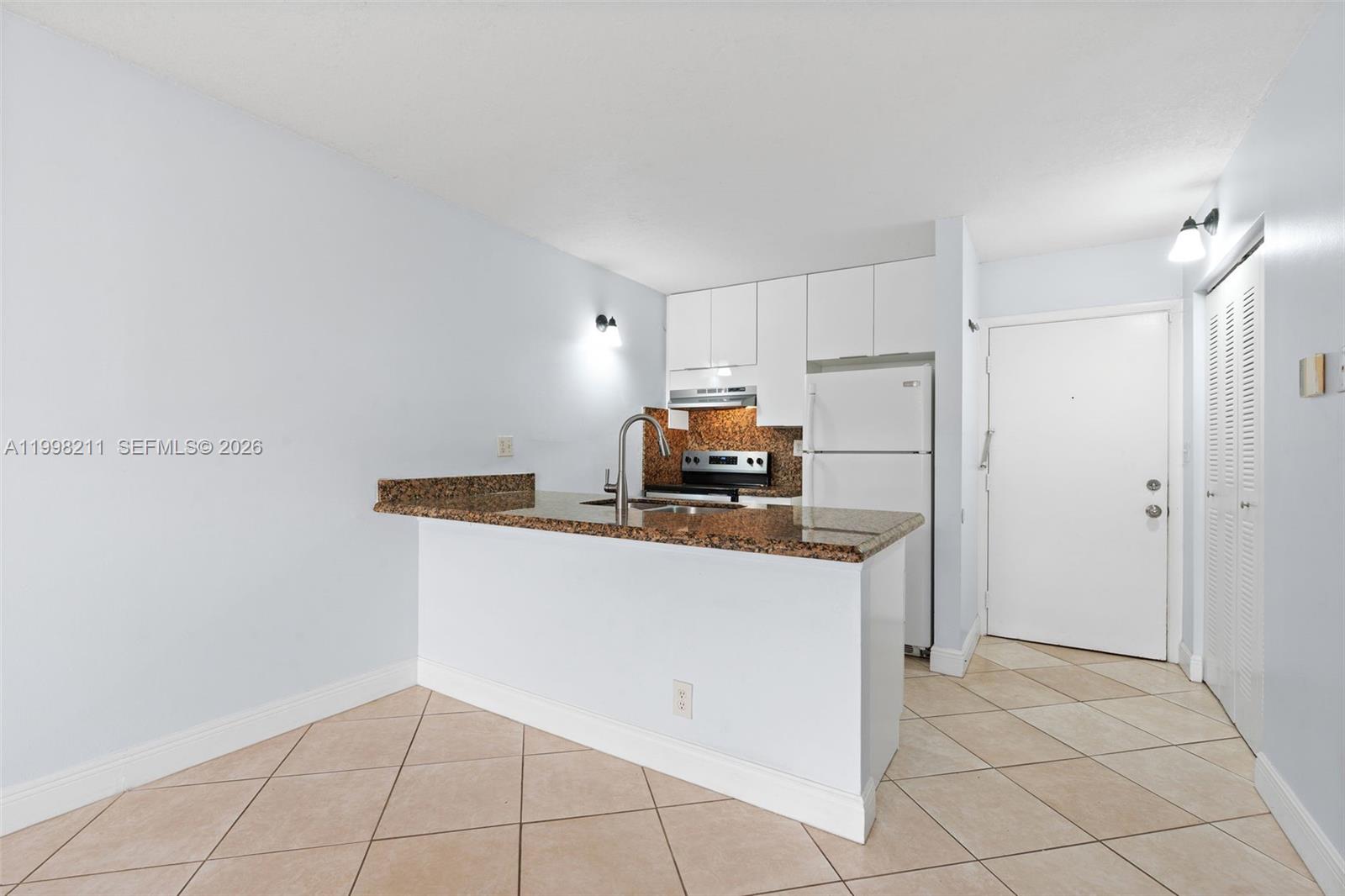 2771 Riverside Drive, Unit 316A Coral Springs, FL 33065 - Photo 5 of 20 a kitchen with kitchen island a sink a stove and a refrigerator