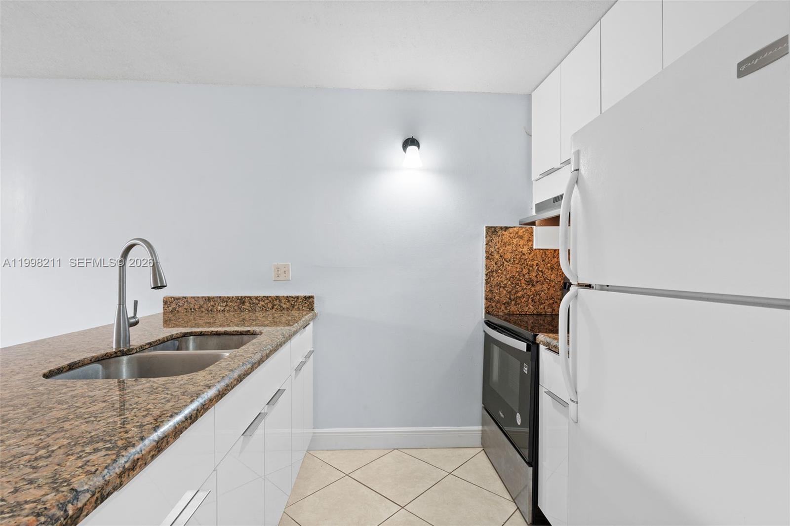 2771 Riverside Drive, Unit 316A Coral Springs, FL 33065 - Photo 7 of 20 a kitchen with refrigerator and window