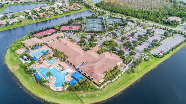 an aerial view of a swimming pool a house with yard and seating area