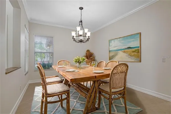 a dining room with furniture a chandelier and wooden floor