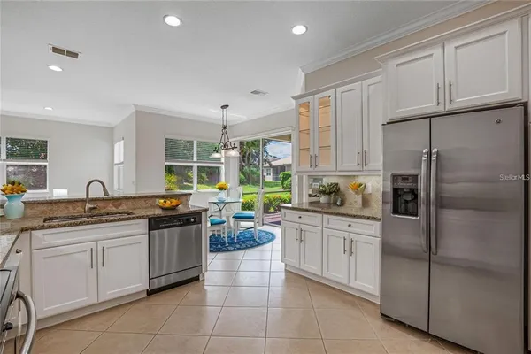 a kitchen with stainless steel appliances granite countertop a refrigerator sink and cabinets