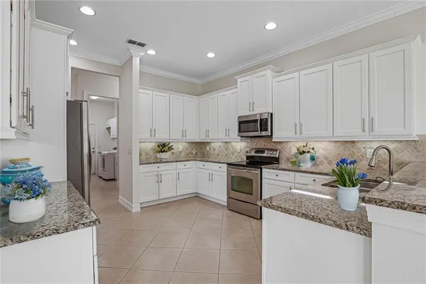a kitchen with granite countertop stainless steel appliances a sink a counter top space cabinets and a counter top space