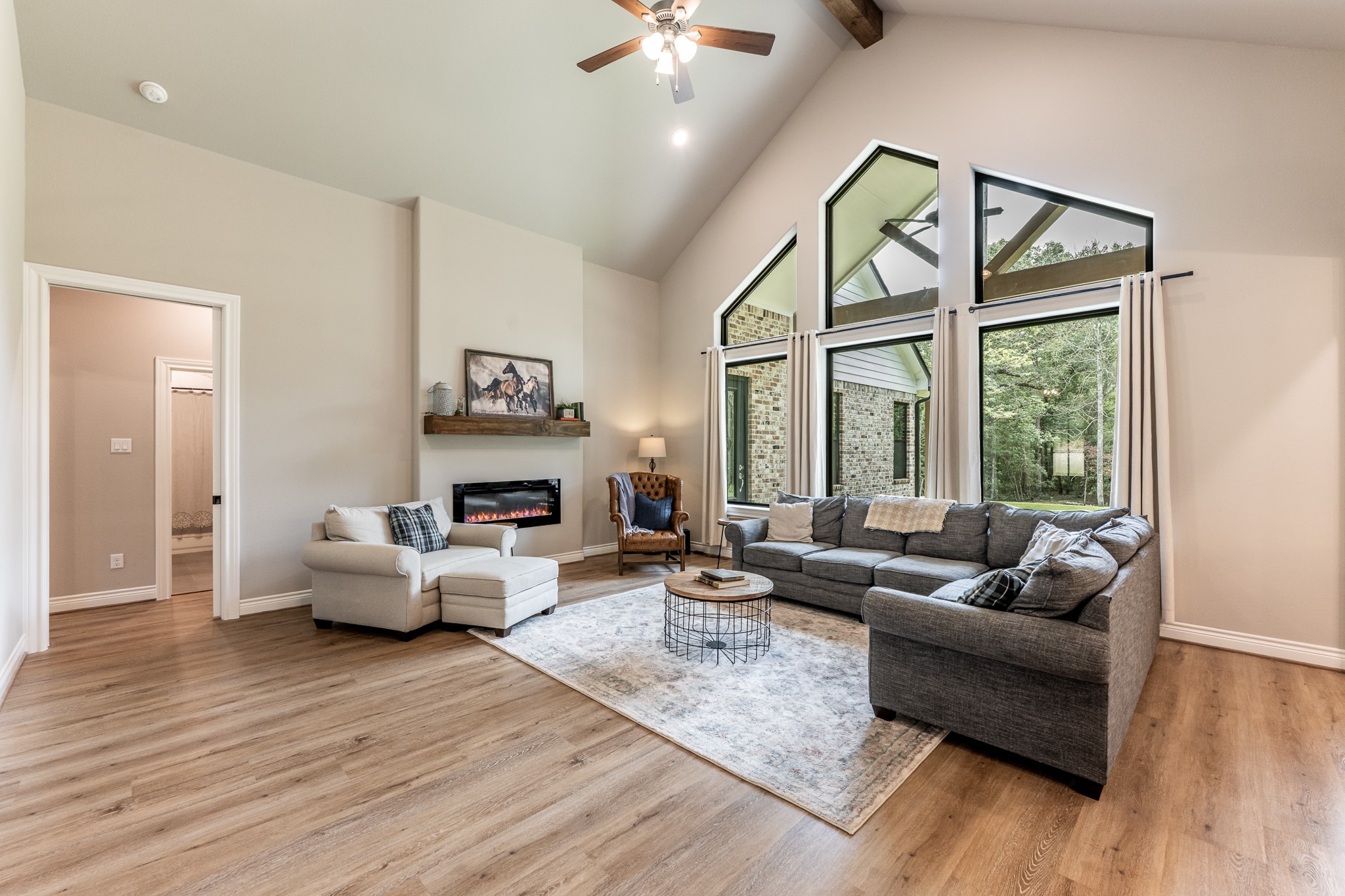111 Eagle Run Road Willis, TX 77378 - Photo 10 of 44 Elegant living room featuring a soaring beamed ceiling and a cozy electric fireplace.