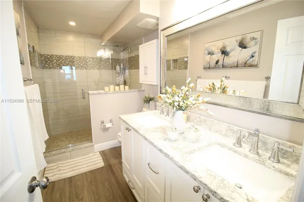 a bathroom with a sink a toilet and shower