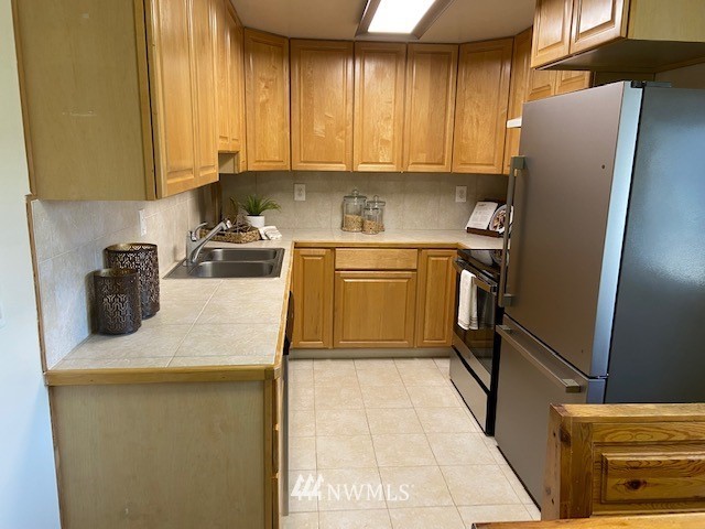 859 Queen Avenue Northeast Renton, WA 98056 - Photo 5 of 24 a kitchen with stainless steel appliances granite countertop a refrigerator sink and stove
