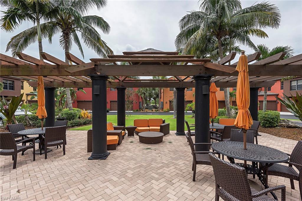 9102 Capistrano Street South, Unit 723 Naples, FL 34113 - Photo 3 of 12 a backyard of a house with barbeque oven table and chairs