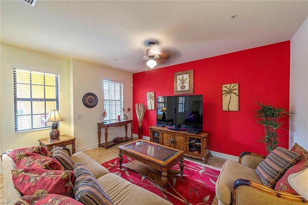 9102 Capistrano Street South, Unit 723 Naples, FL 34113 - Photo 4 of 12 a living room with furniture and a flat screen tv