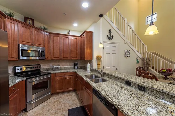 a kitchen with stainless steel appliances granite countertop a sink a stove and oven