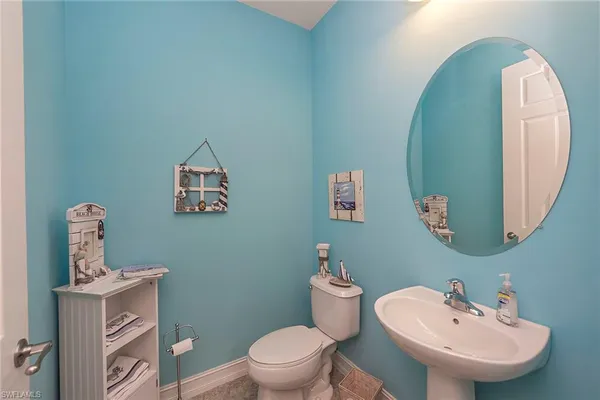 a bathroom with a toilet sink and mirror
