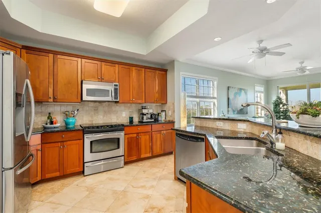 a kitchen with stainless steel appliances granite countertop a sink stove and refrigerator