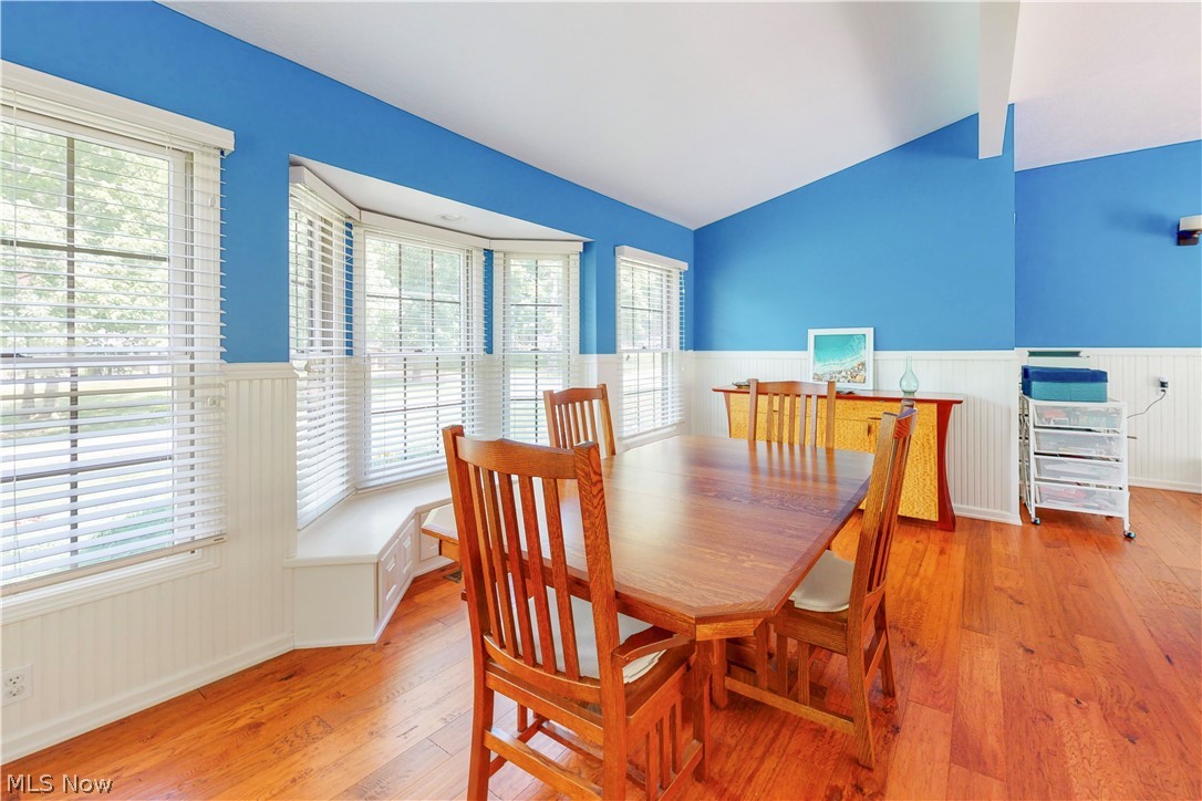 86532 North Bay Road Scio, OH 43988 - Photo 15 of 48 Dining area featuring wood-finish flooring, wainscoting, a vaulted ceiling, and a built-in window bench with integrated storage