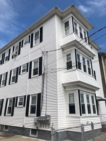 a white building with a window and balcony