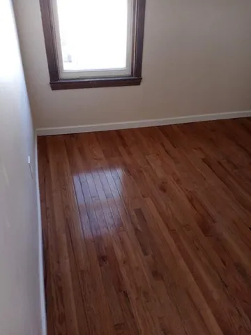 a view of a small space with wooden floor and a window