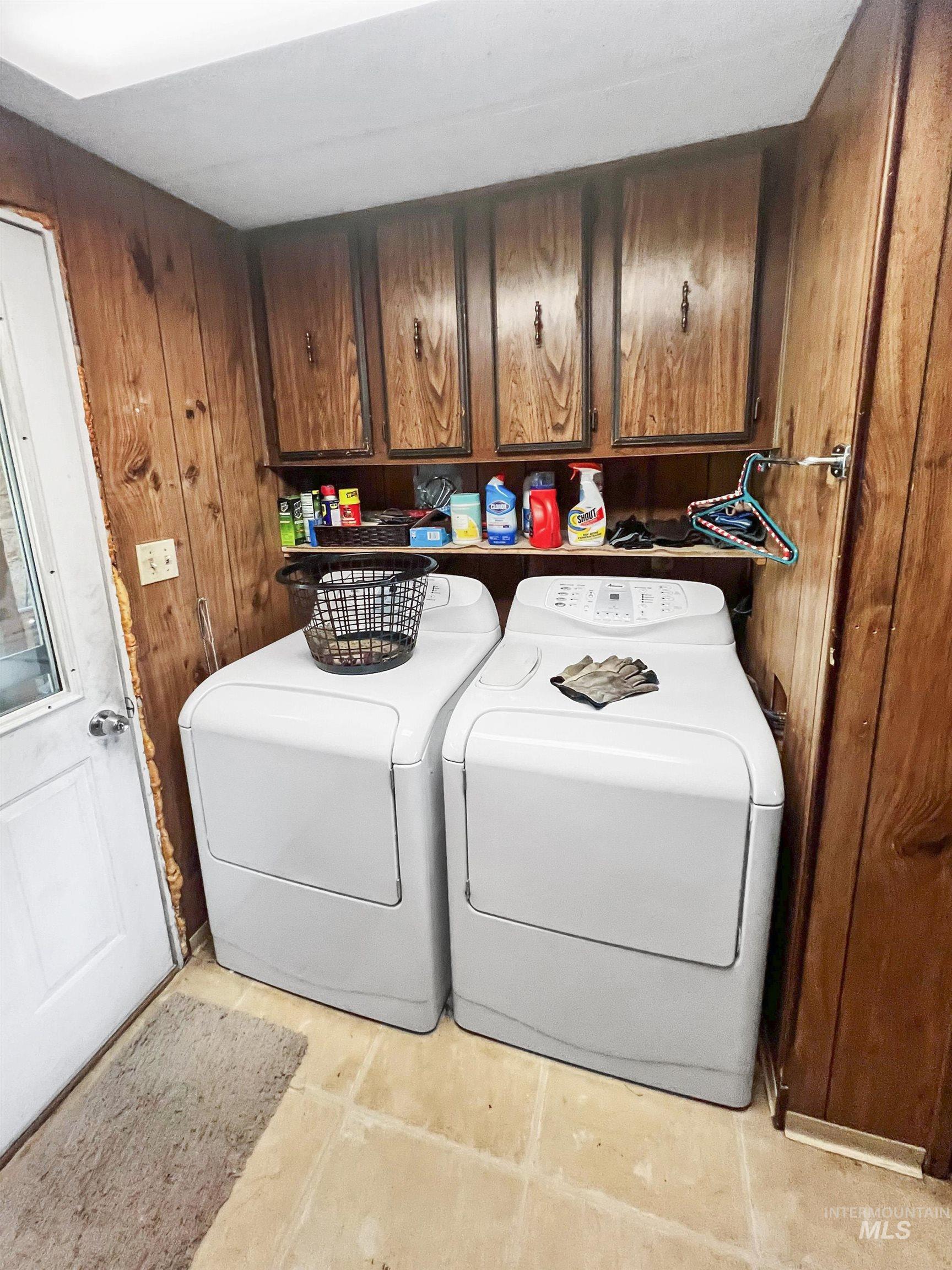 955 South Main Street, Unit 30 Cascade, ID 83611 - Photo 11 of 19 Laundry area with wood walls, washer and clothes dryer, cabinet space, and light tile patterned flooring