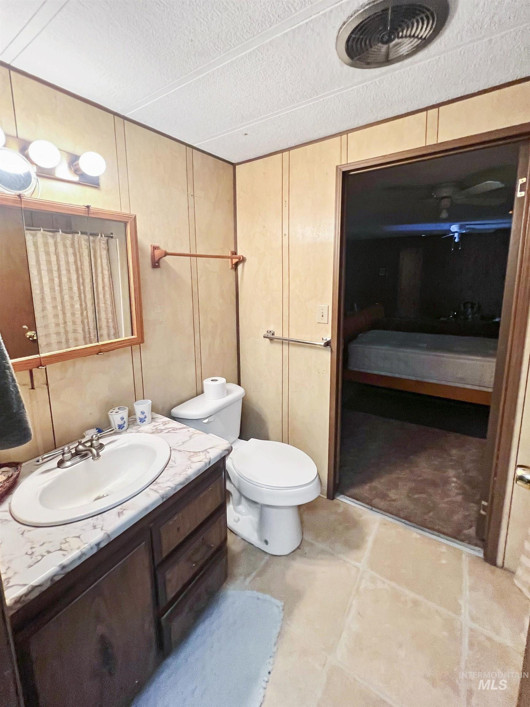 955 South Main Street, Unit 30 Cascade, ID 83611 - Photo 12 of 19 Full bathroom with vanity, connected bathroom, a textured ceiling, and light tile patterned floors