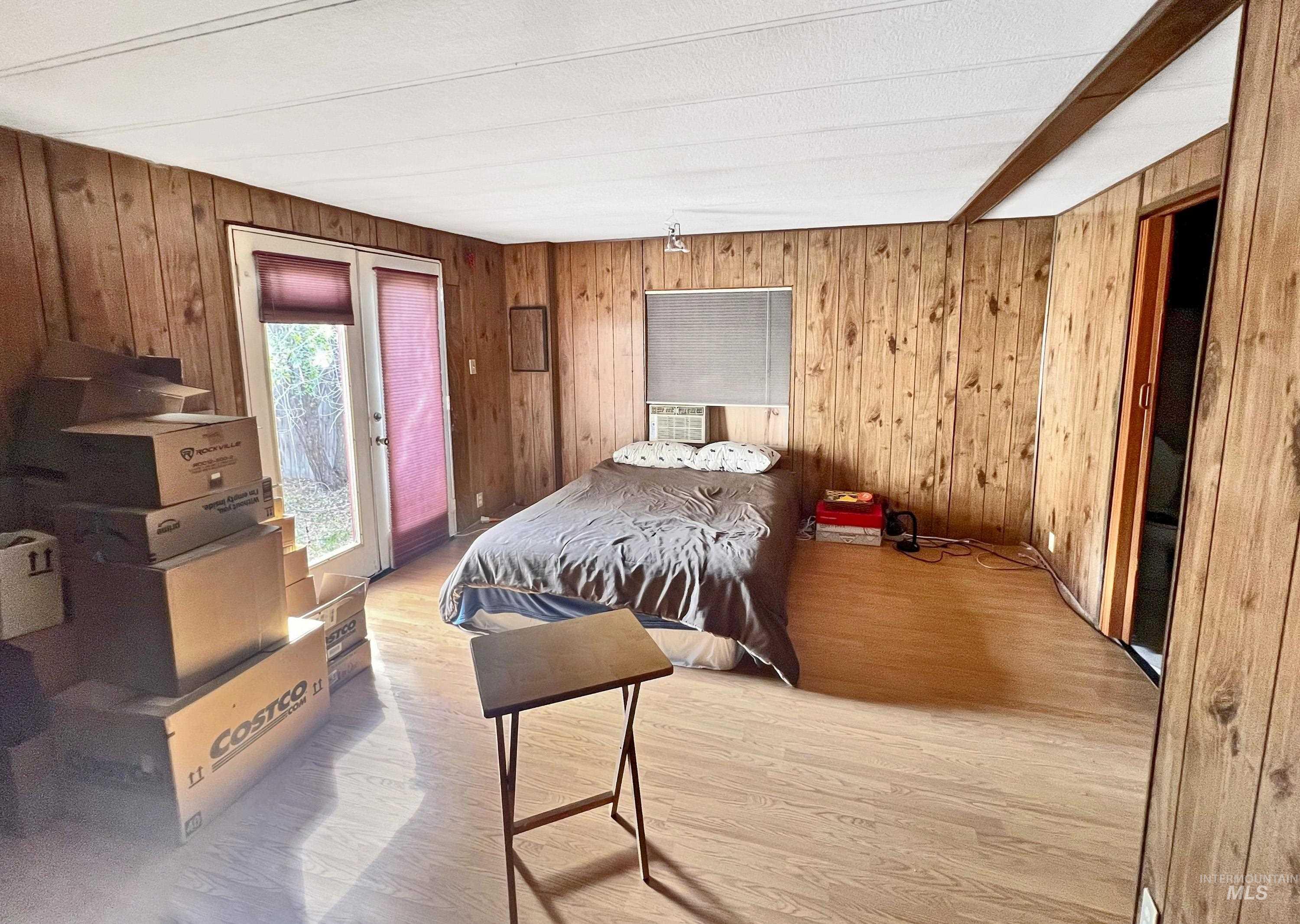955 South Main Street, Unit 30 Cascade, ID 83611 - Photo 15 of 19 Bedroom with wooden walls, light wood-type flooring, access to exterior, and cooling unit