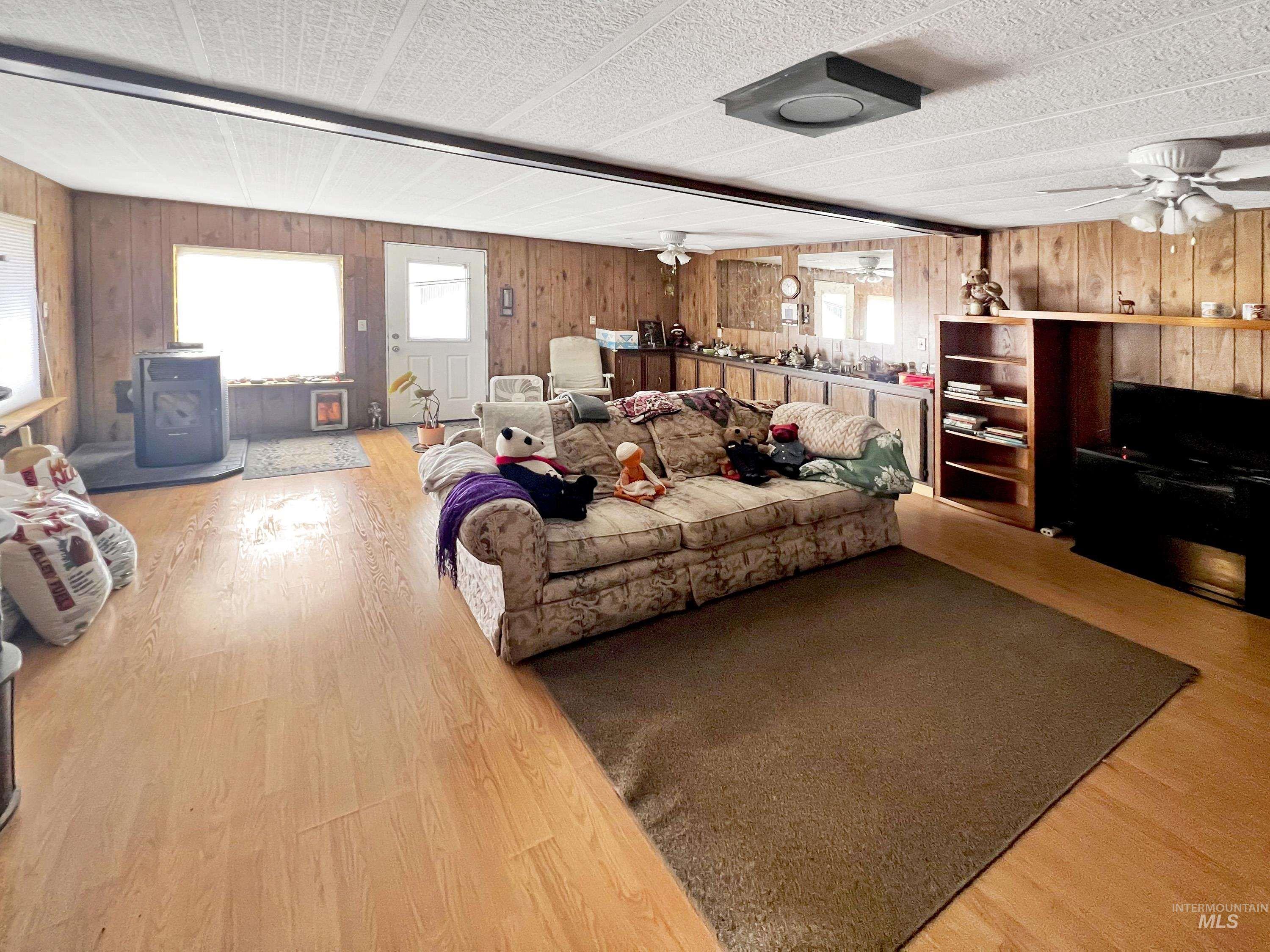 955 South Main Street, Unit 30 Cascade, ID 83611 - Photo 8 of 19 Living area featuring a ceiling fan, plenty of natural light, light wood-style flooring, and wood walls