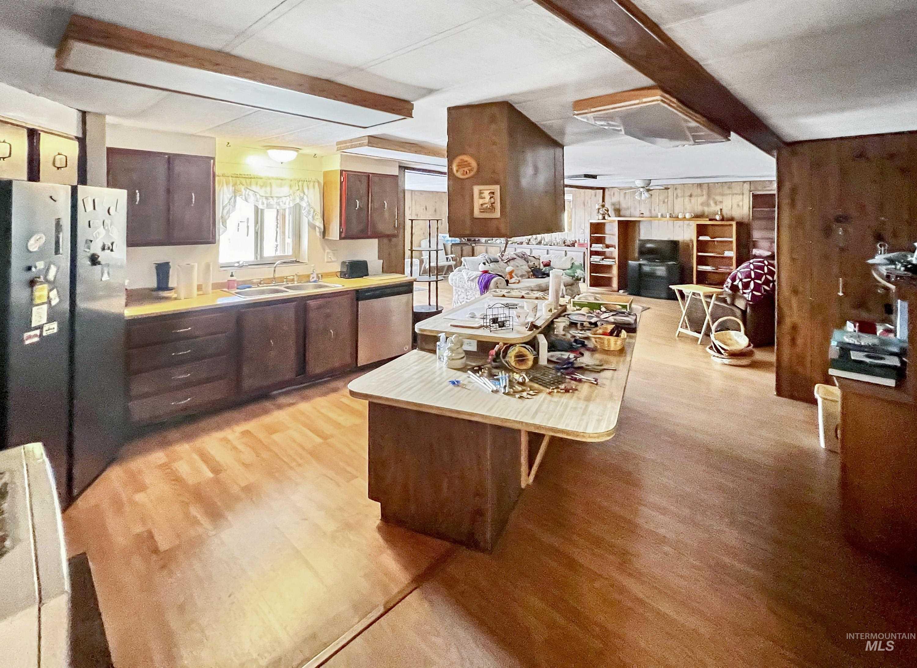 955 South Main Street, Unit 30 Cascade, ID 83611 - Photo 10 of 19 Kitchen featuring light countertops, appliances with stainless steel finishes, dark brown cabinetry, a kitchen breakfast bar, and light wood-type flooring