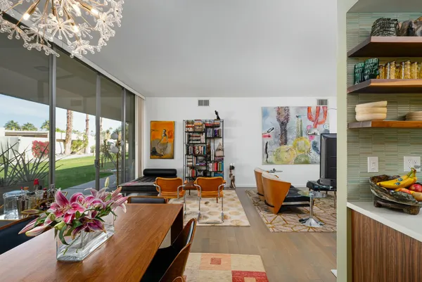 a view of a dining room with furniture a chandelier and wooden floor