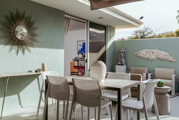 a living room with patio furniture and a potted plant
