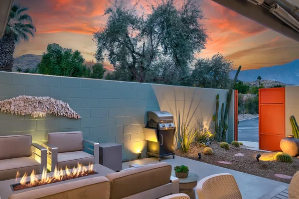 an outdoor living area with furniture and a fireplace
