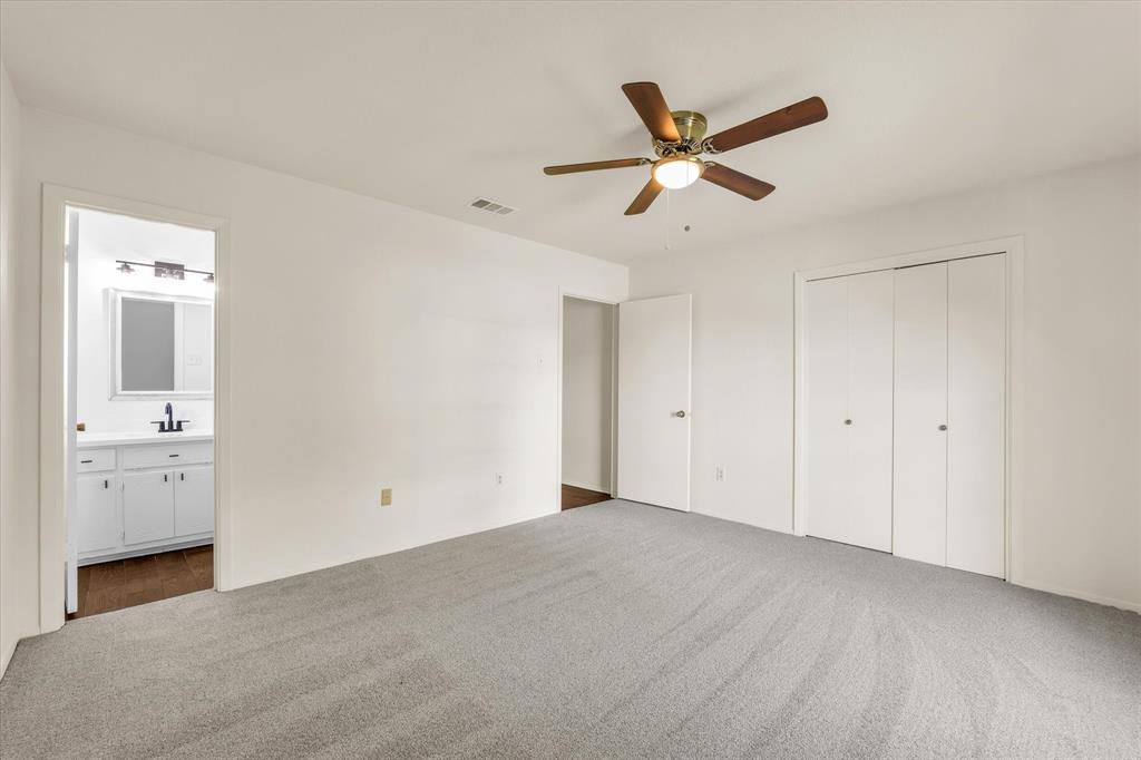 141 Travis Lane Hewitt, TX 76643 - Photo 14 of 31 Spacious room featuring light gray carpet flooring, a ceiling fan with wood-finish blades, and double bi-fold closet doors