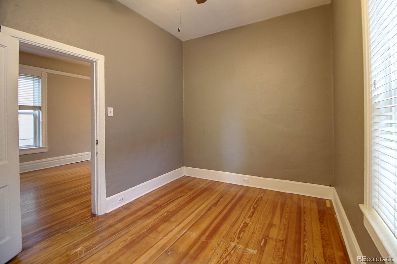 328 Inca Street Denver, CO 80223 - Photo 14 of 35 an empty room with wooden floor and windows