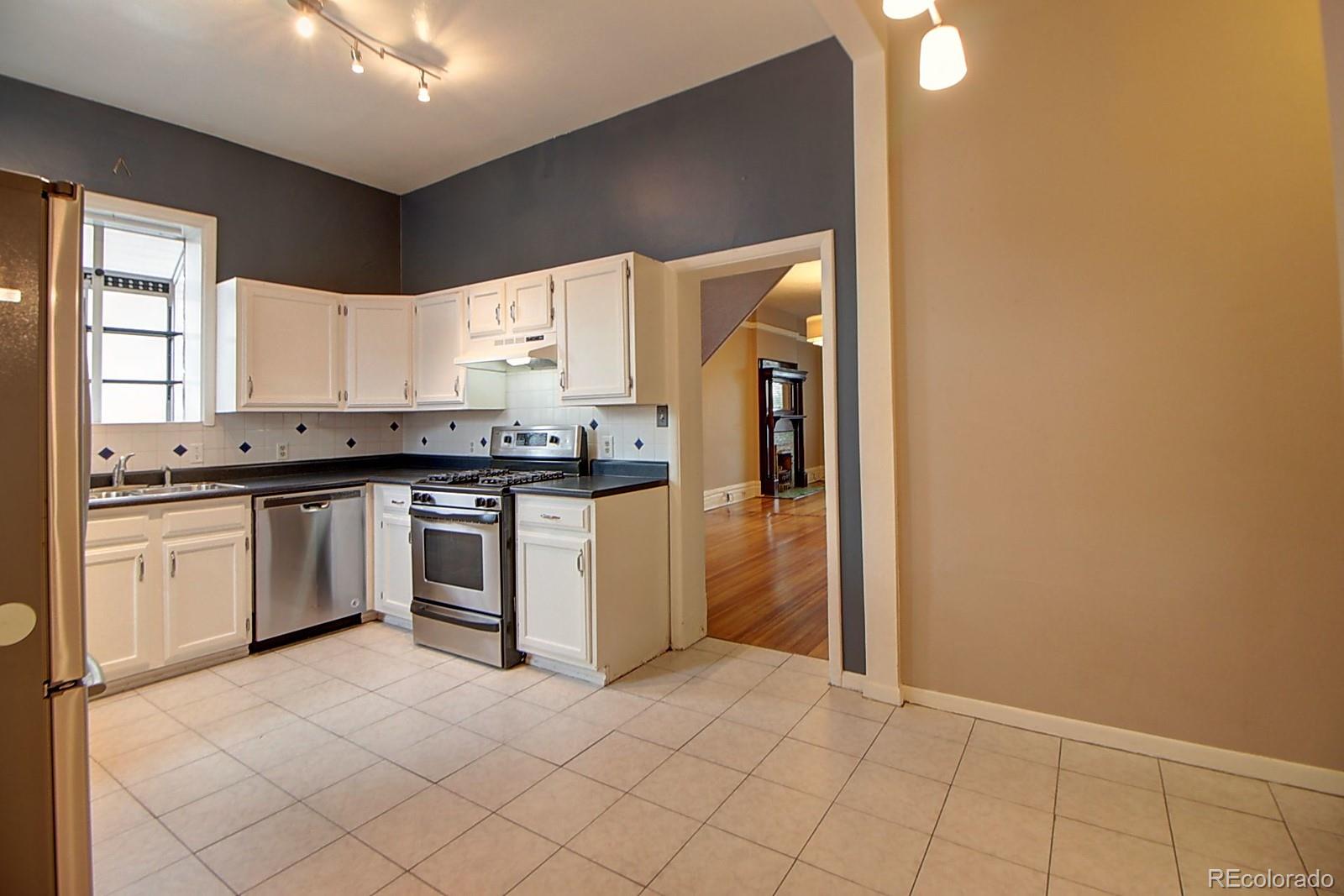 328 Inca Street Denver, CO 80223 - Photo 19 of 35 a kitchen with white cabinets and appliances