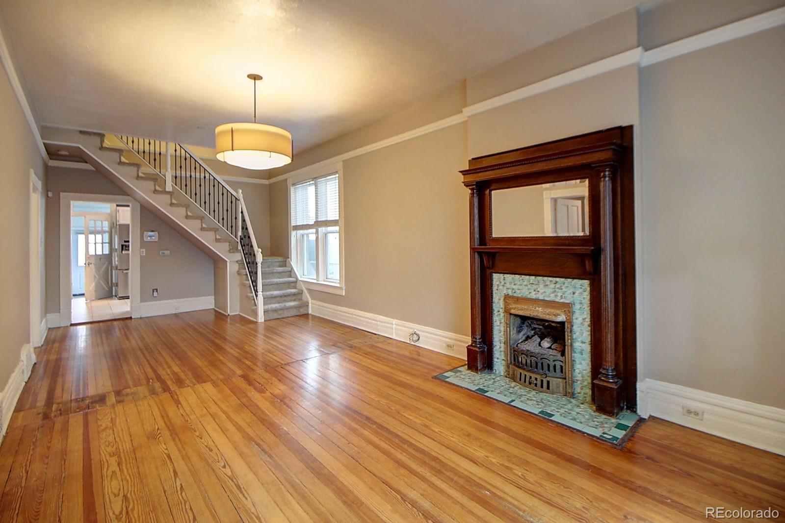 328 Inca Street Denver, CO 80223 - Photo 3 of 35 a view of main area a fireplace and wooden floor