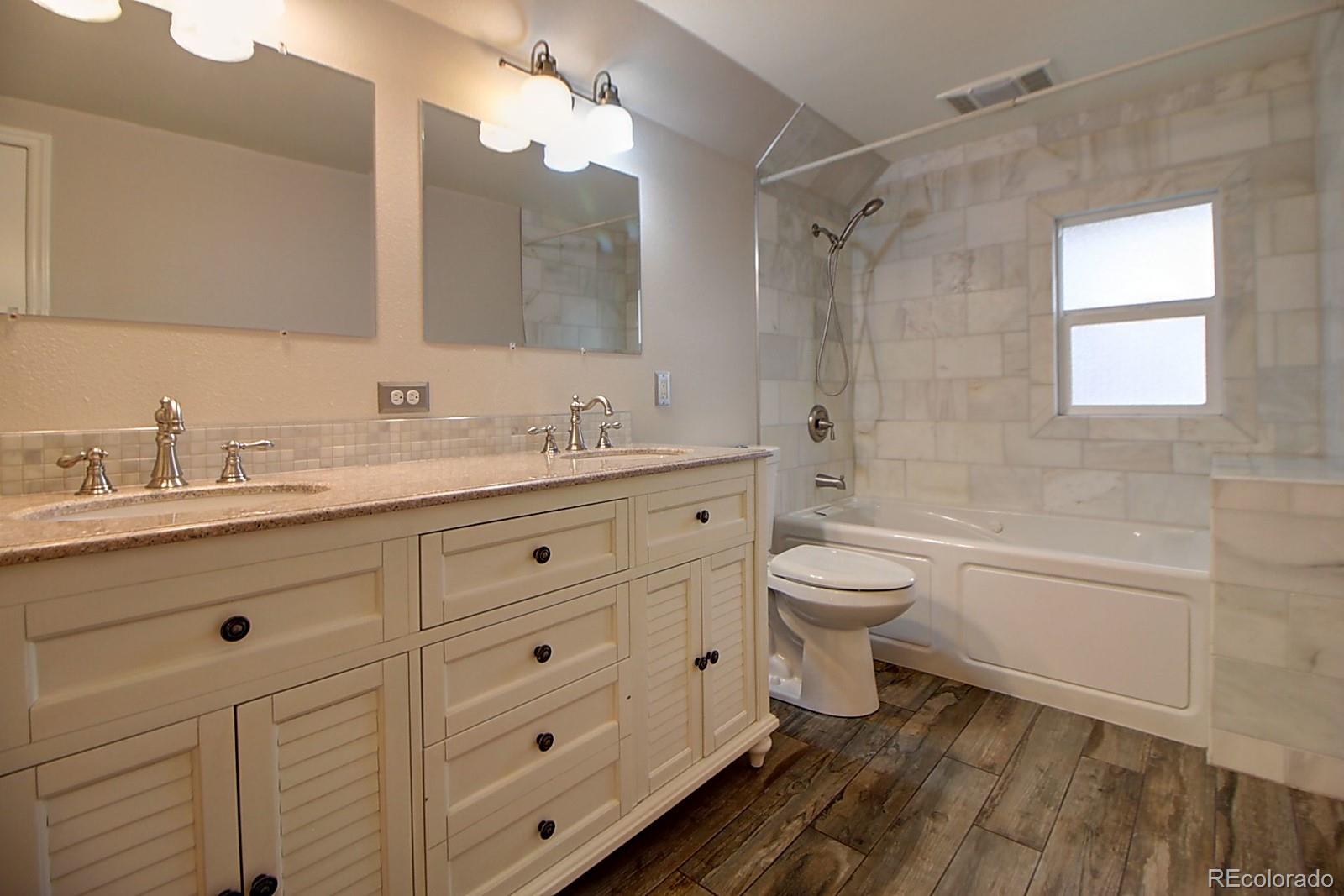 328 Inca Street Denver, CO 80223 - Photo 33 of 35 a bathroom with a double vanity sink toilet mirror and shower