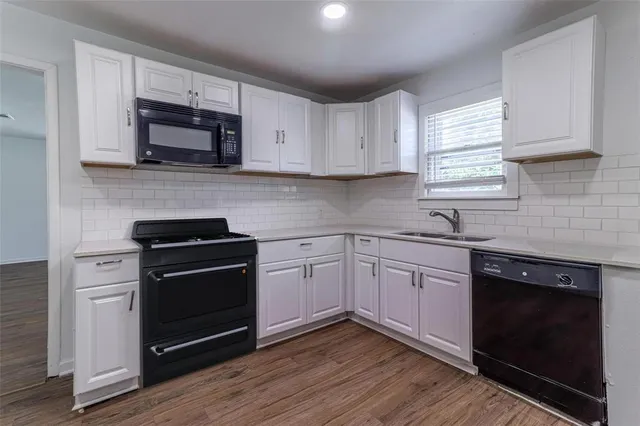 a kitchen with cabinets stainless steel appliances and wooden floor