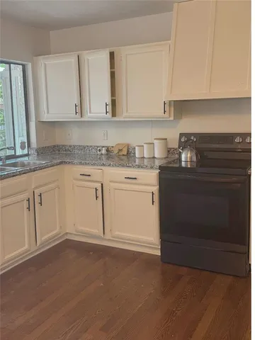 a kitchen with white cabinets appliances and sink